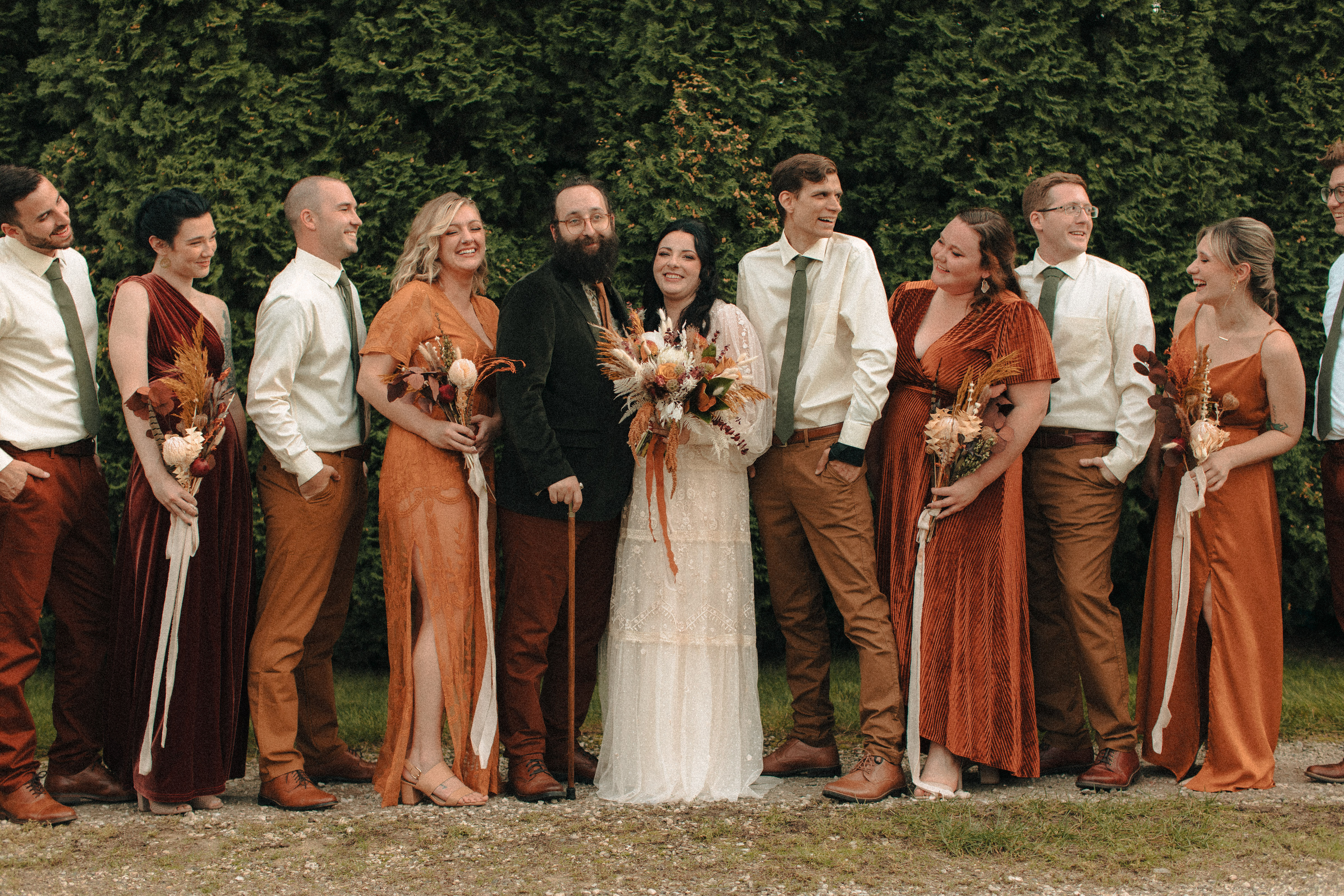 Wedding party wearing creams, golds, oranges, and reds