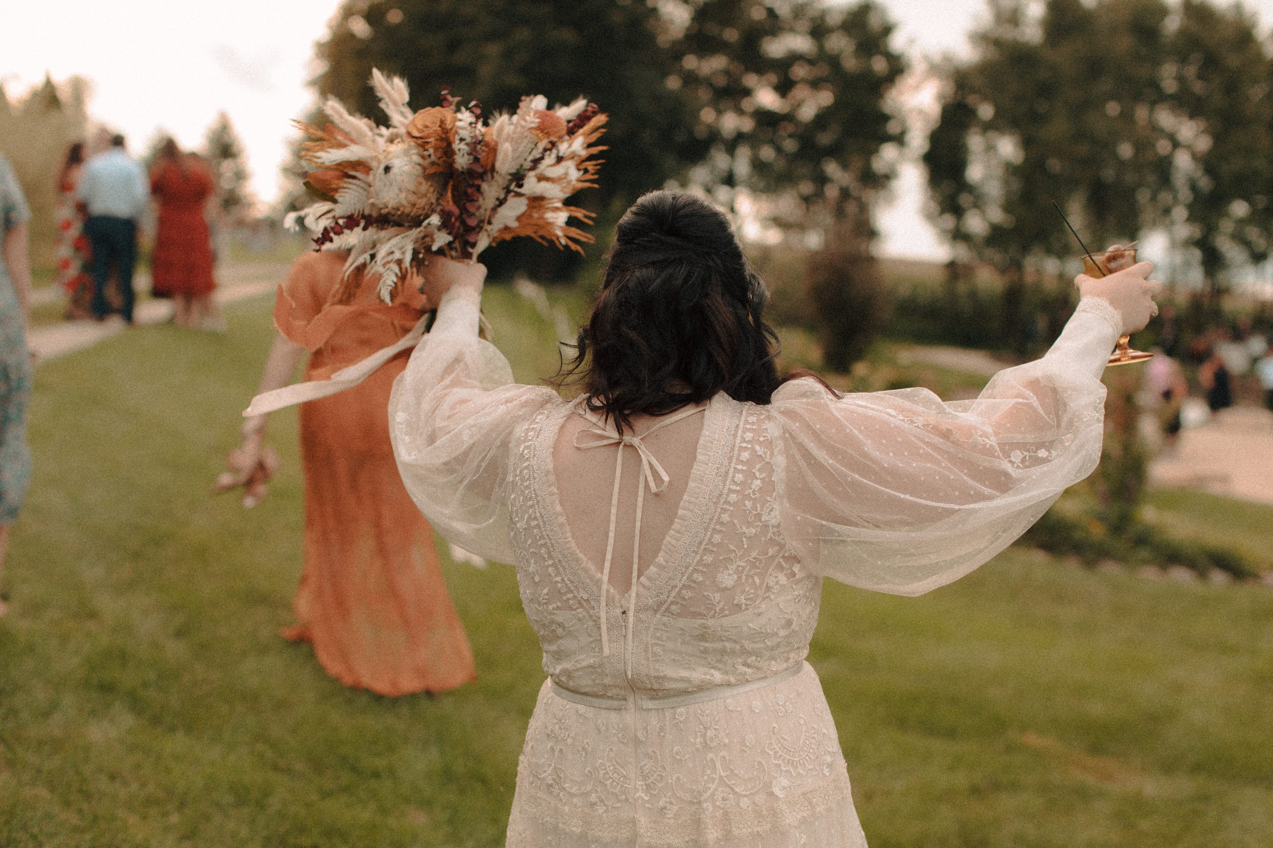 Bride celebrating cocktail hour with hands in the air