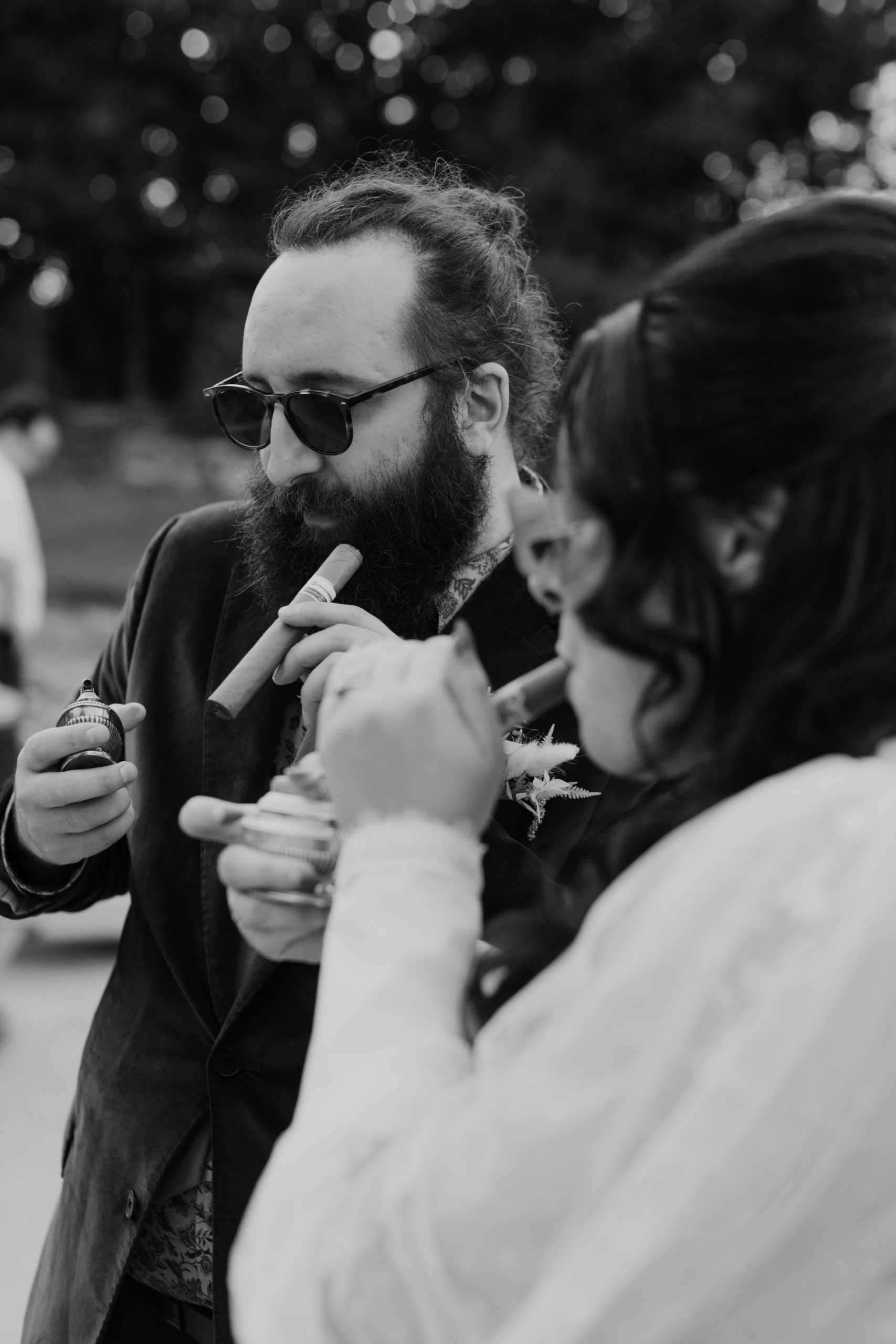 Couple smoking at Speakeasy inspired cigar bar at a wedding with vintage lighters