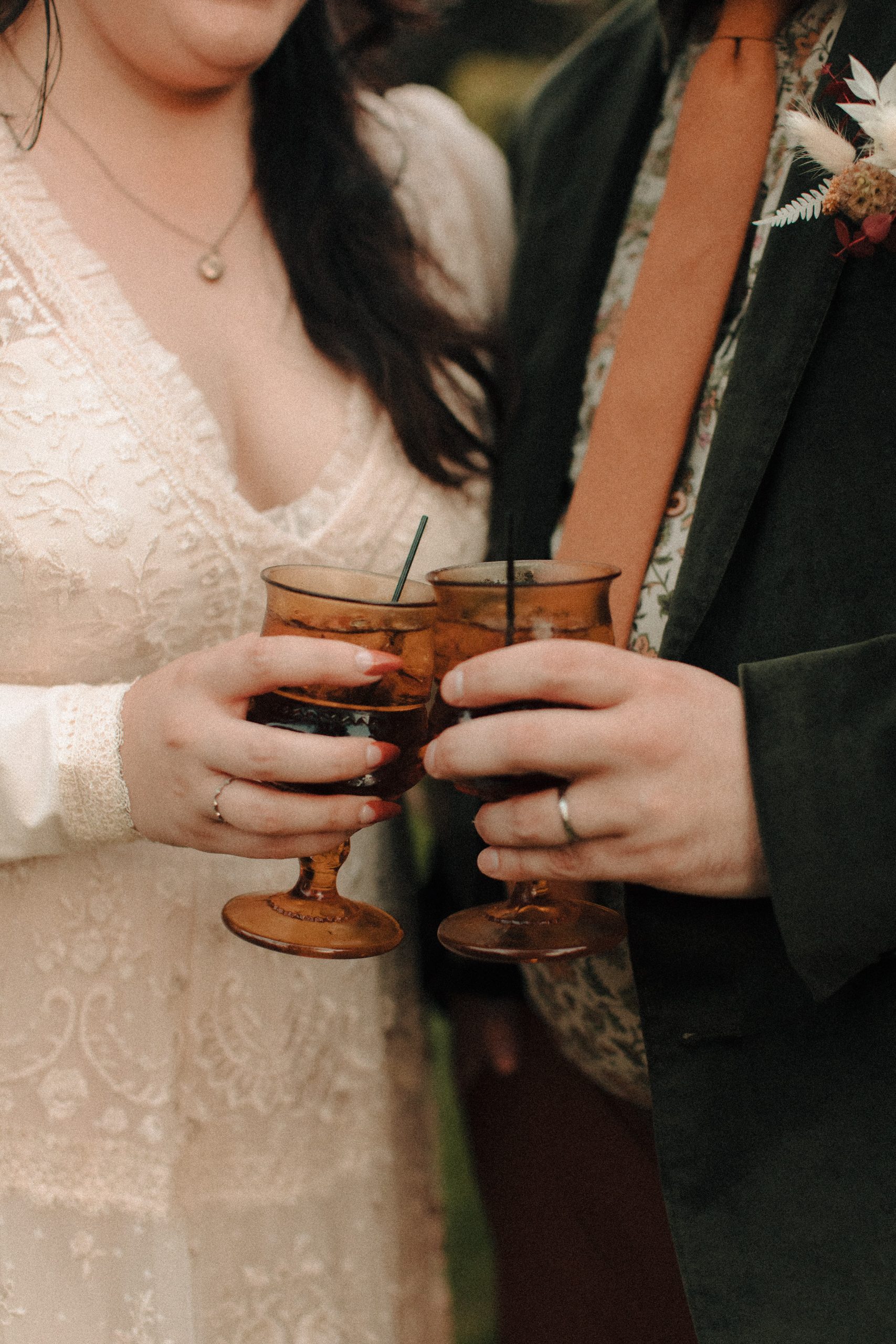 Bride and groom clinking amber glasses