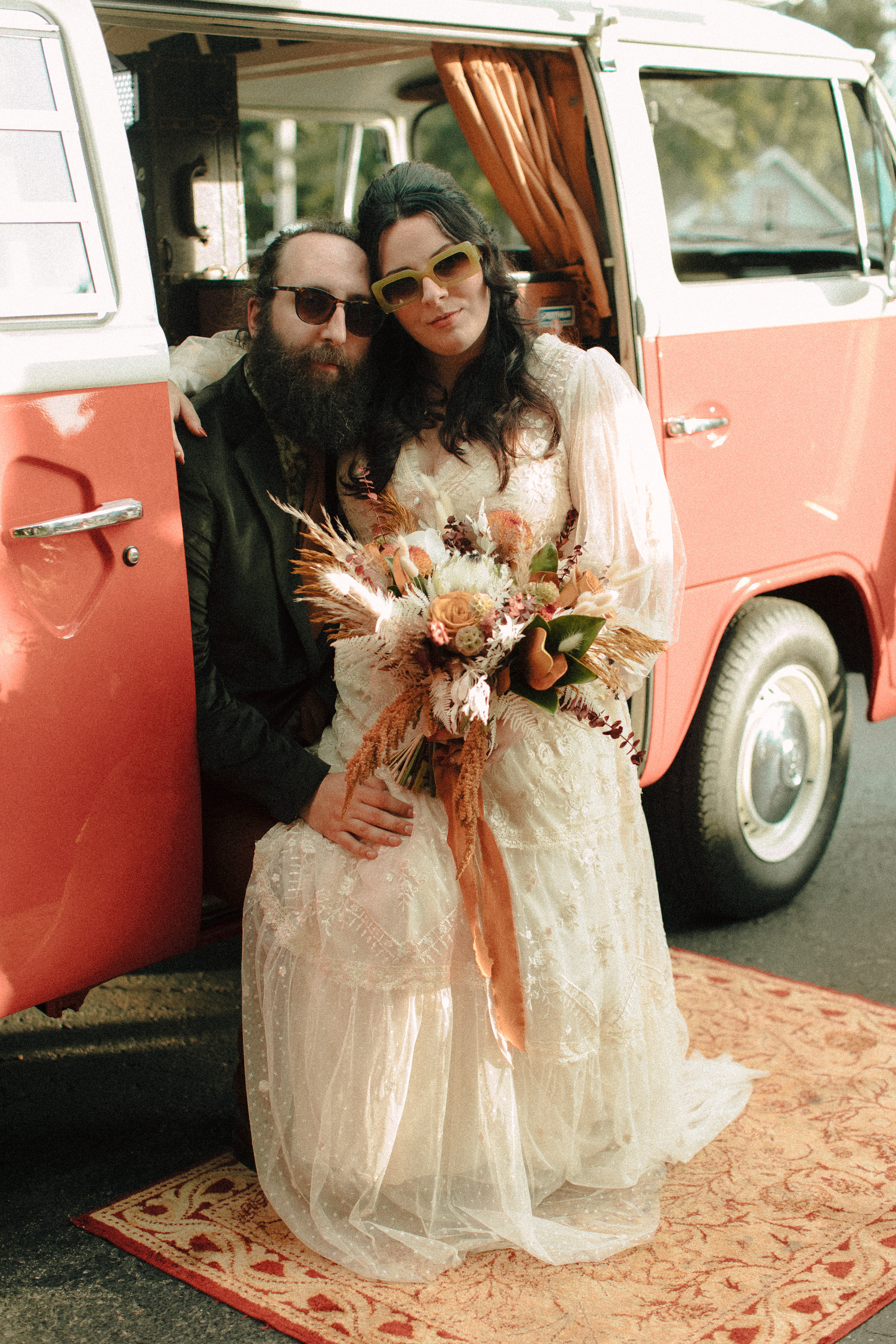 Vintage bride and groom sitting in a retro VW bus