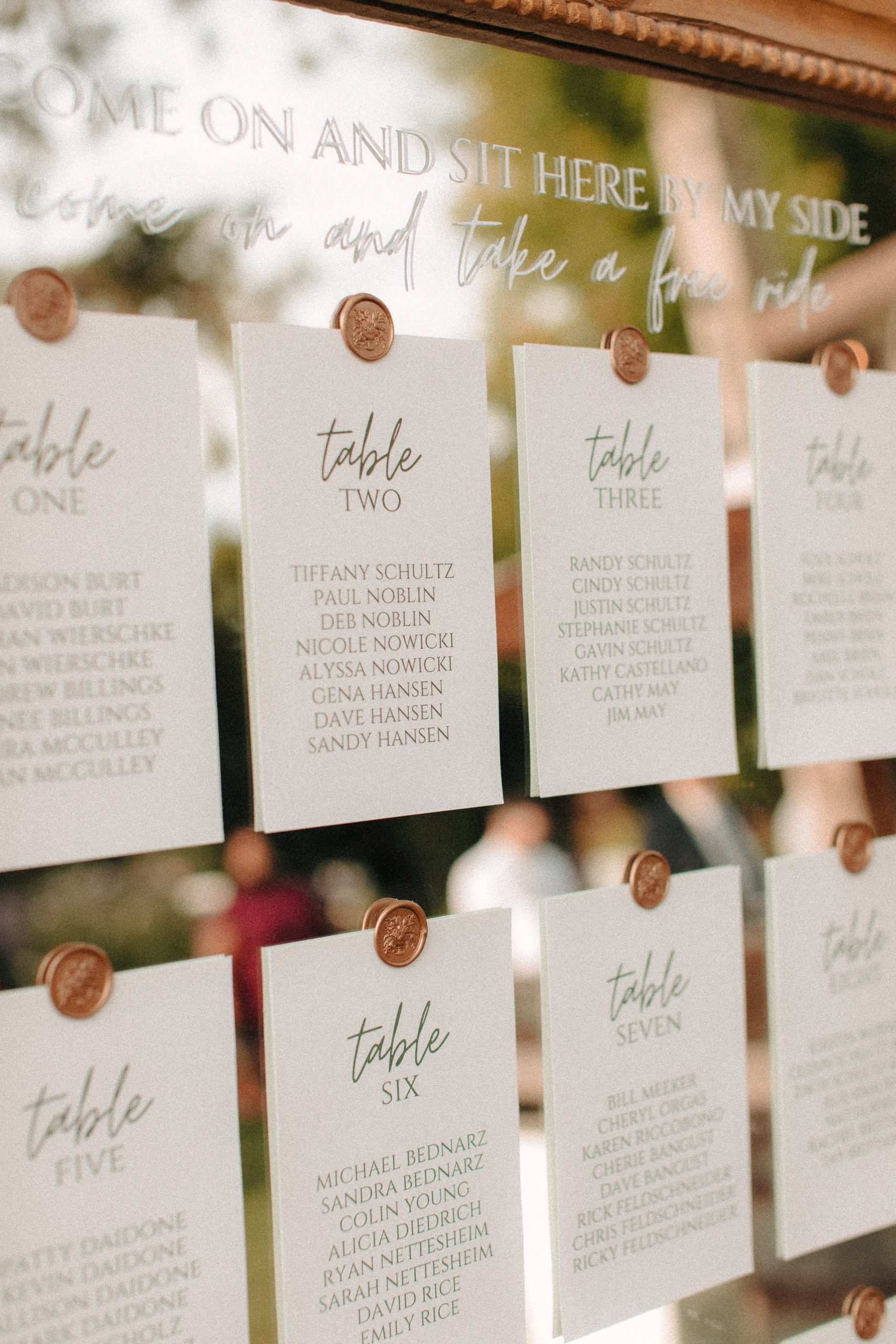 Table numbers tuck to a mirror using wax seals
