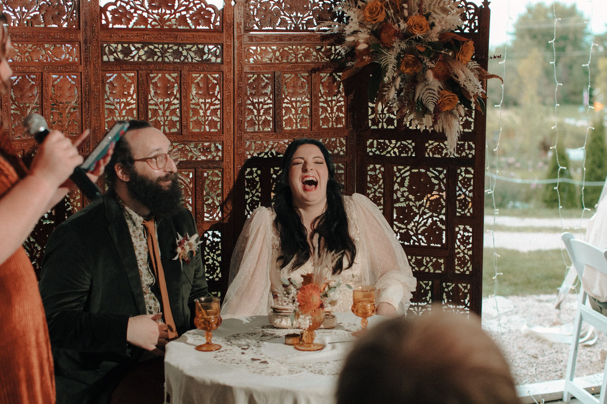 Bride and groom laughing at wedding speech