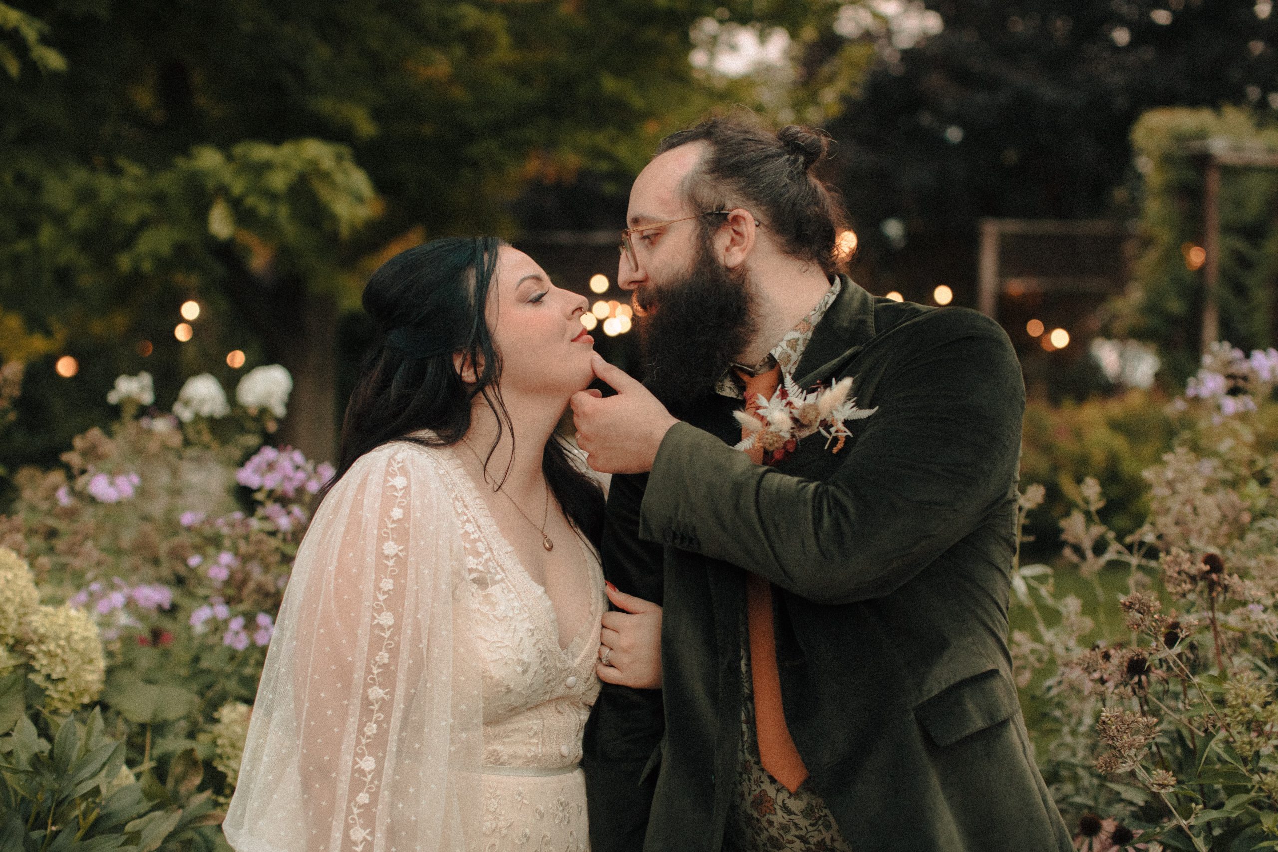 Romantic image of groom pulling his bride in for a kiss in a garden