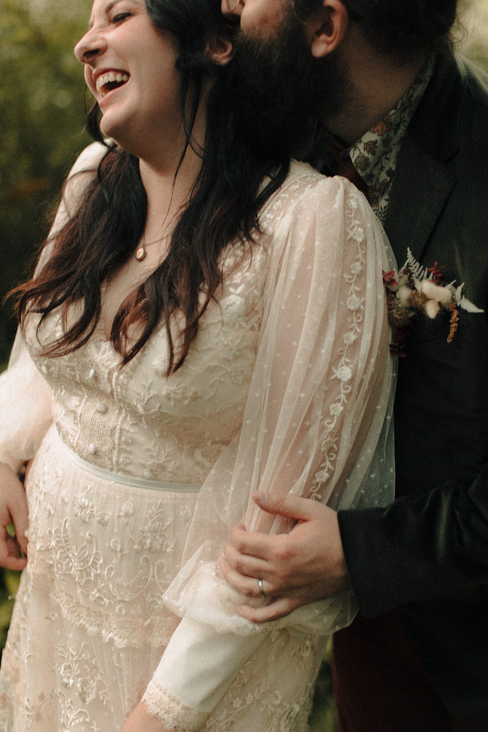 custom wedding dress sleeves on a bride getting hugged from behind by groom