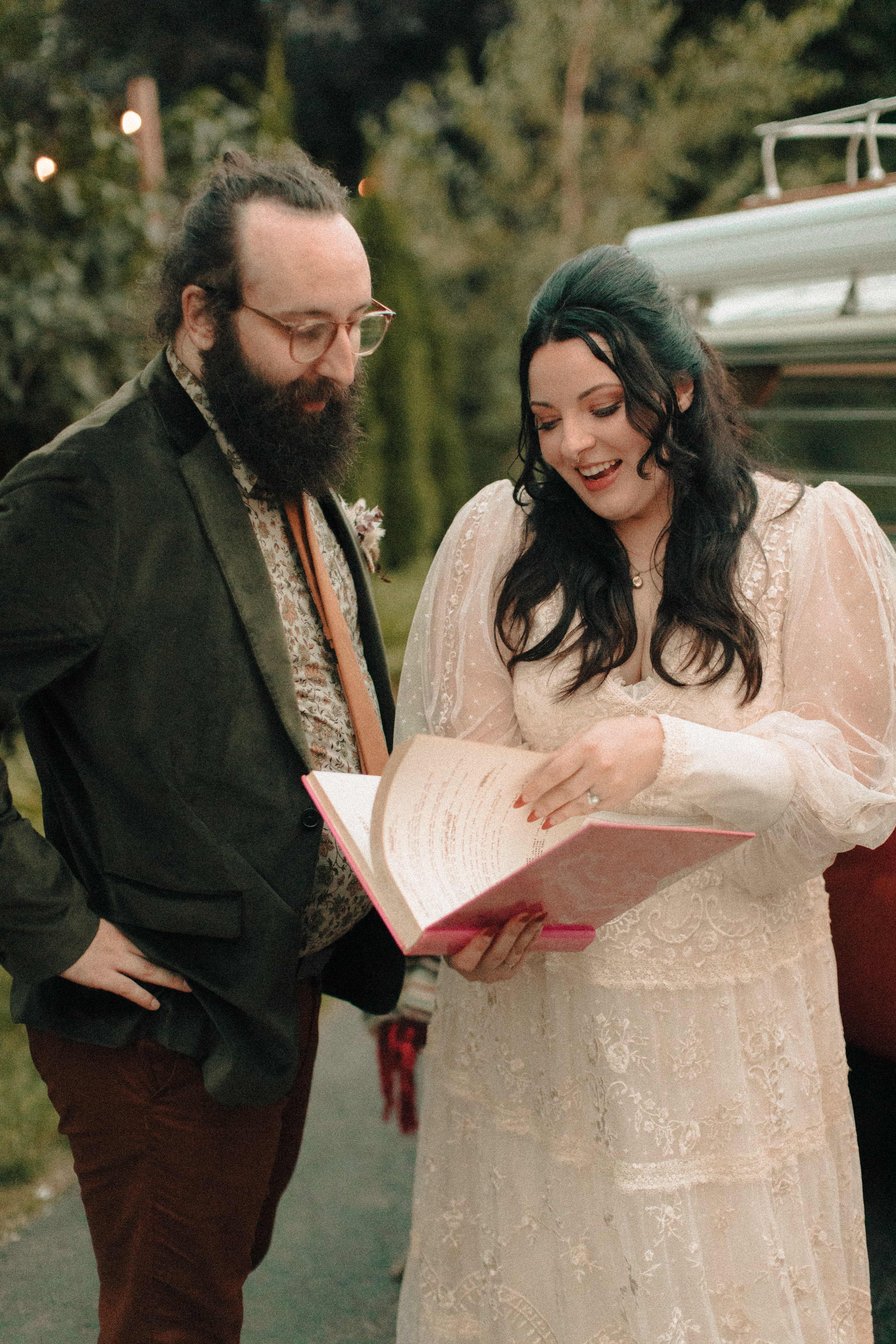 Bride in front of a vw bus holding a bob dylan book