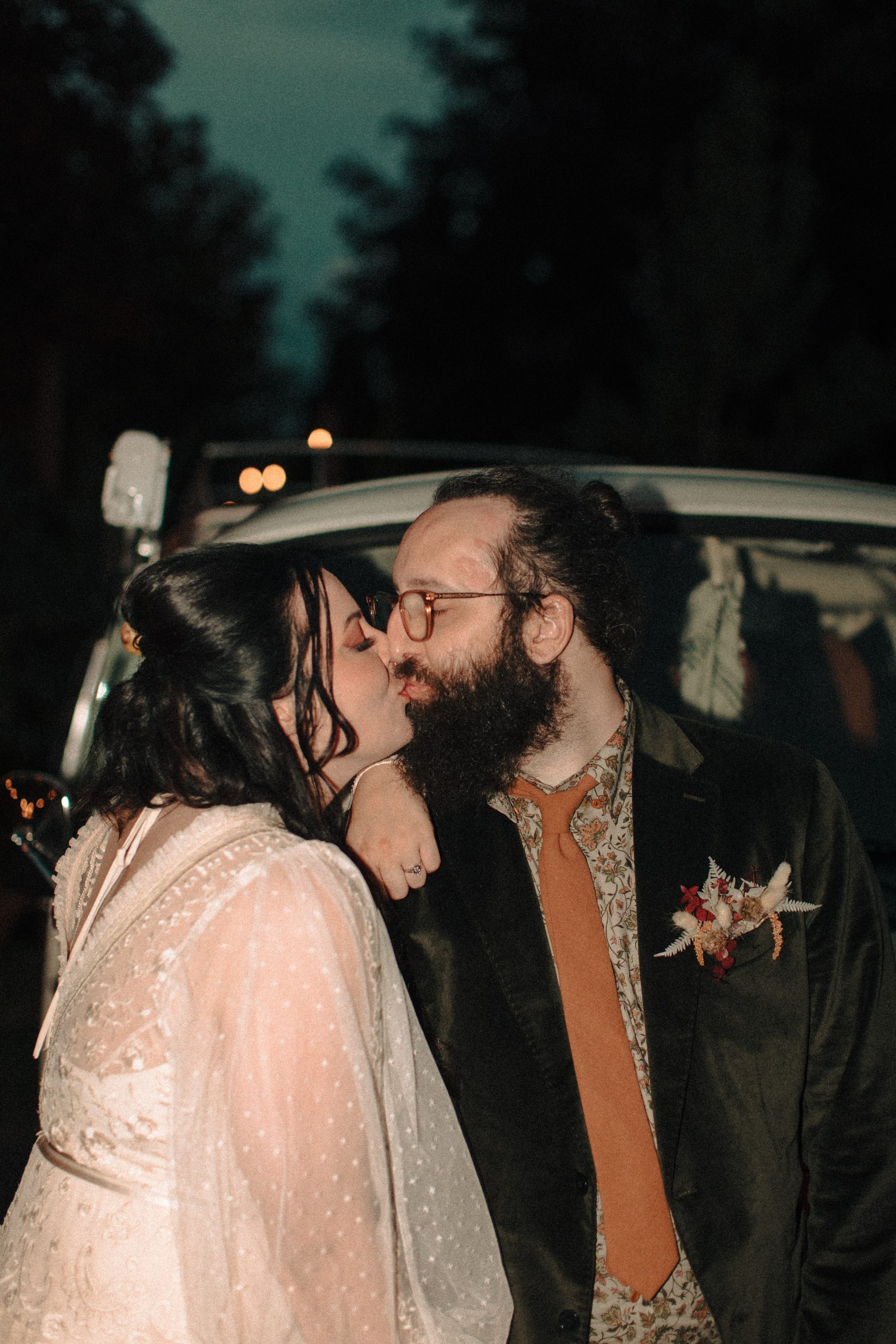 retro bride and groom kissing in front of a red Volkswagen bus