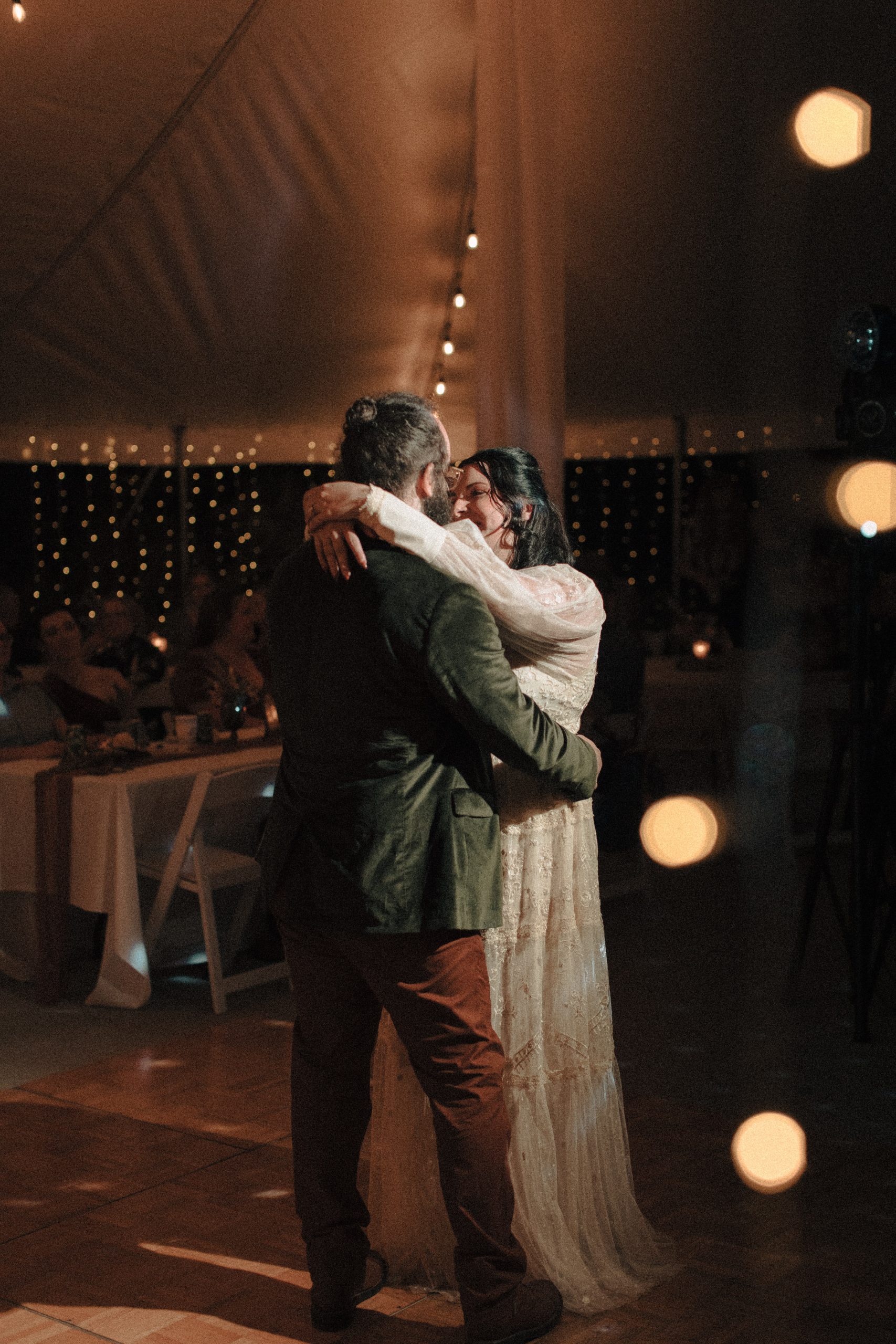 First dance photo under twinkle lights in a tent