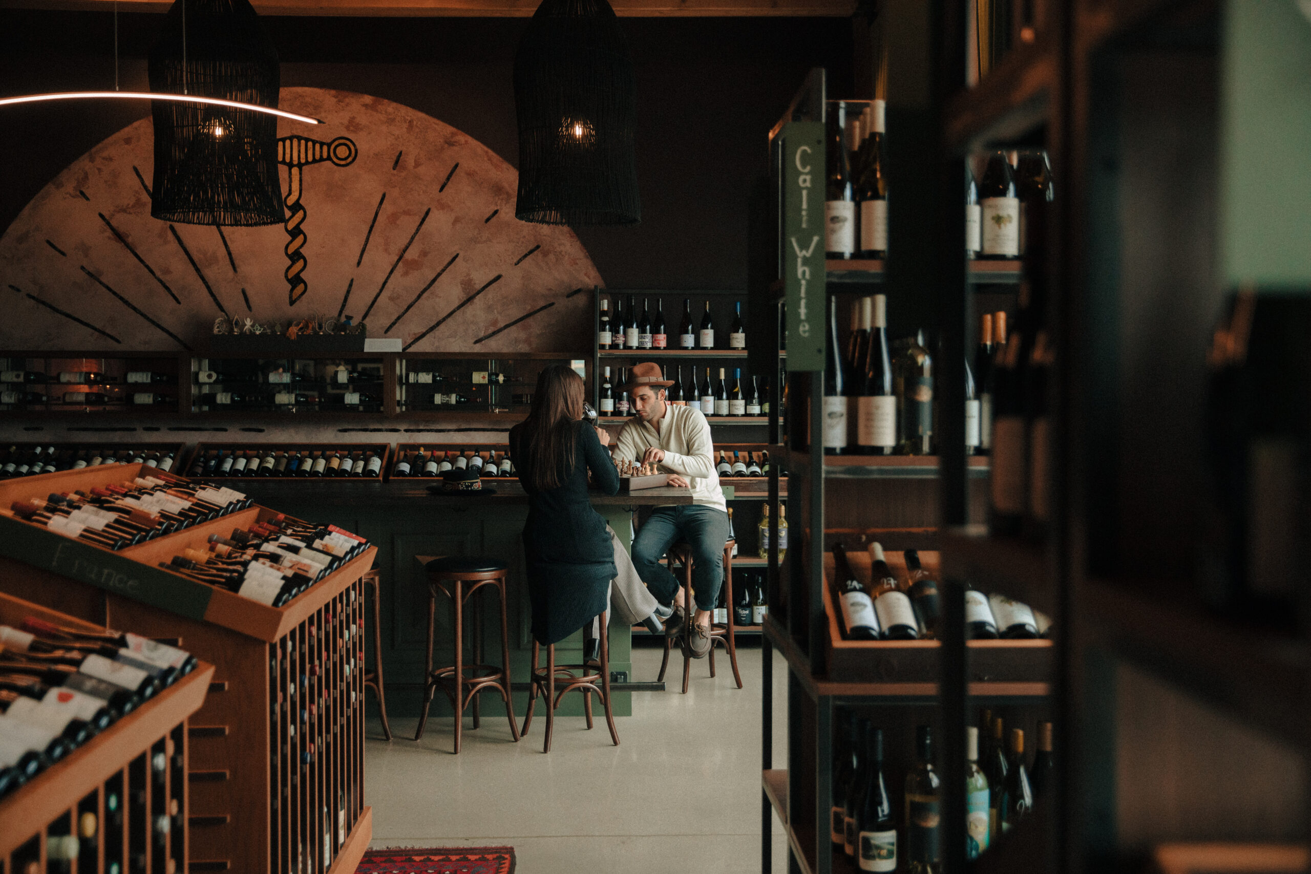 Couple playing chess at a milwaukee wine bar before their third ward proposal